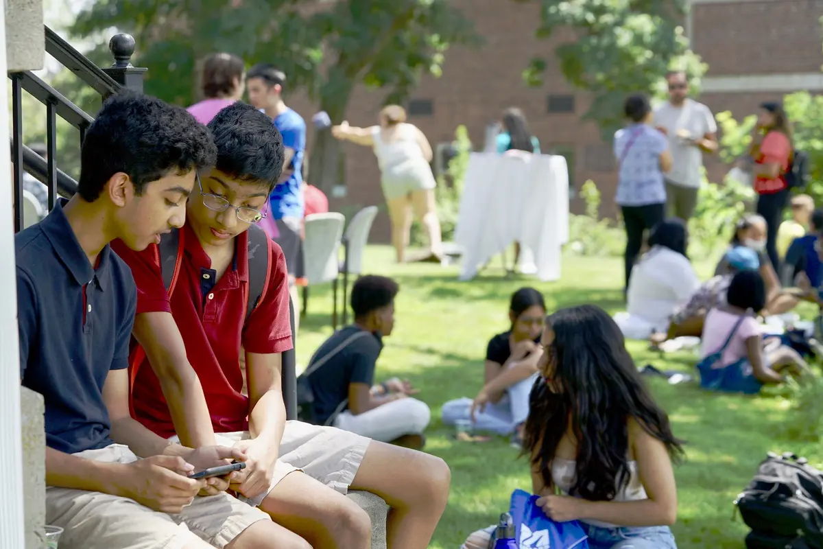 Two boys look at a cell phone