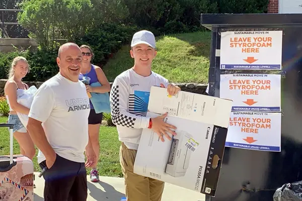 A student and his family dispose of cardboard during move-in