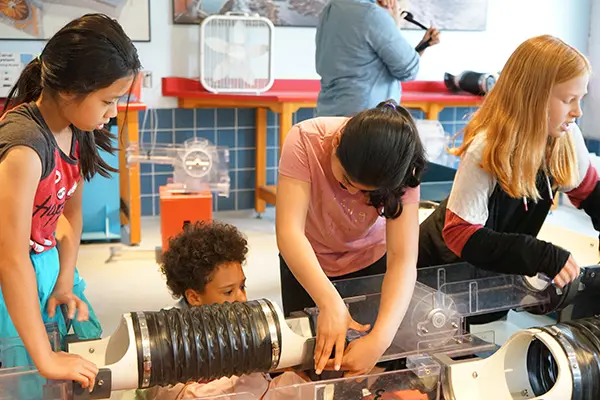 Four girls build a canal system in the Water Power room at the Tsongas Industrial History Center
