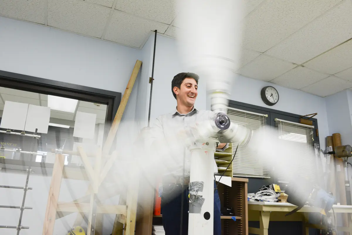 Professor Alessandro Sabato operates a lab-scale wind turbine at the Structural Dynamics and Acoustics Systems Lab