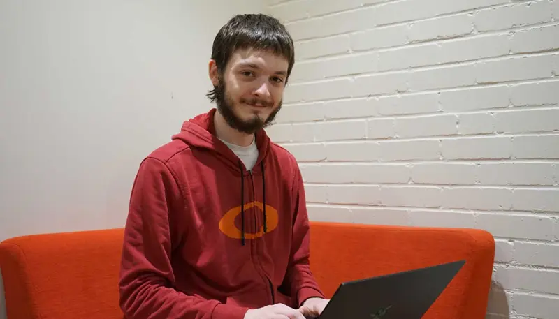 Zach McCann seated with a laptop