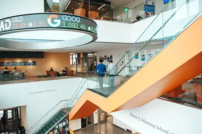 Interior of building with people walking down a staircase,