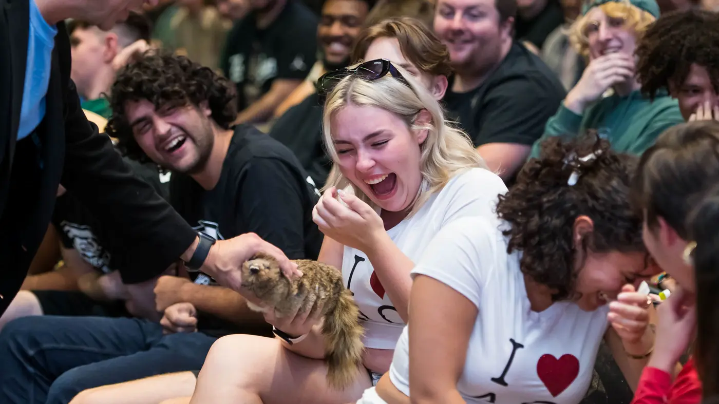 Laughing student petting furry animal