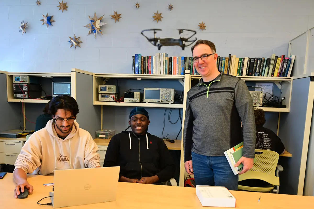 A capstone project team and faculty mentor flying a drone.
