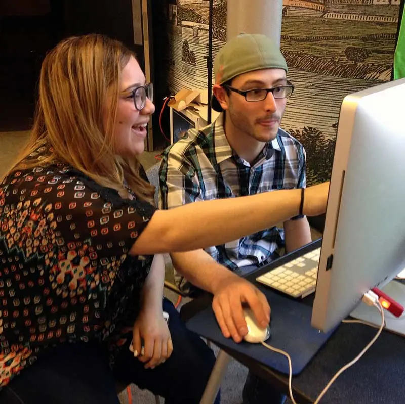 Journalism and Professional Writing students working together on a desktop computer 