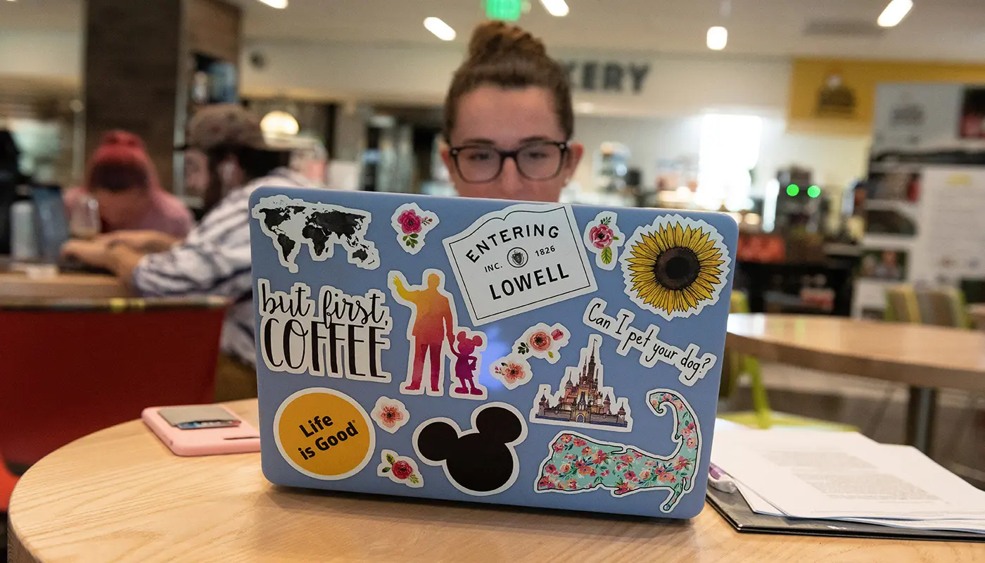 female student sitting at a table on her laptop in McGauvran 
