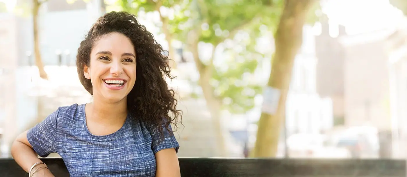 Smiling young woman seated on bench