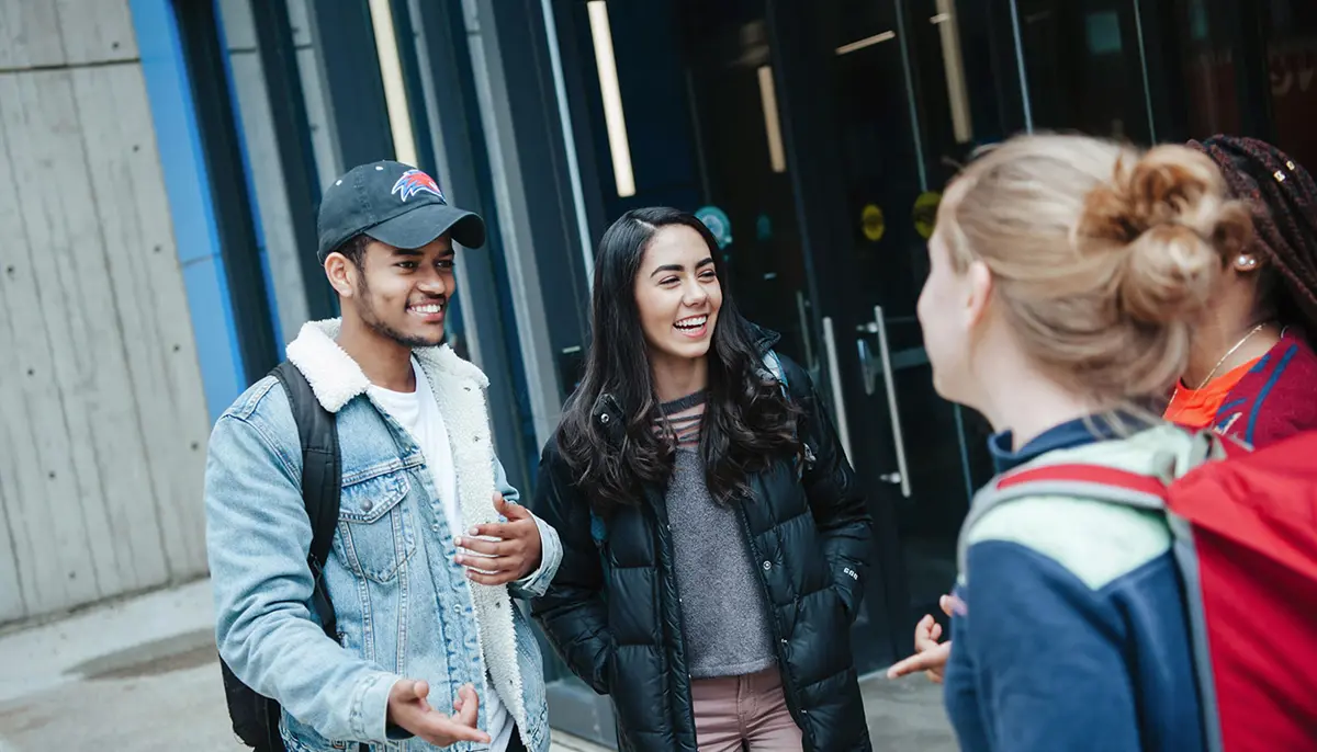 a group of students talking on UMass Lowell's south campus