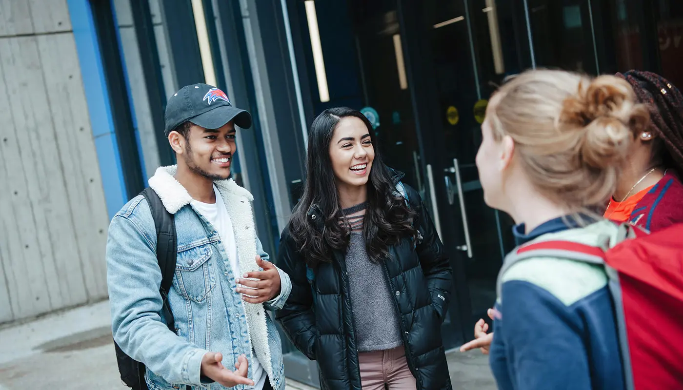 a group of students talking on UMass Lowell's south campus