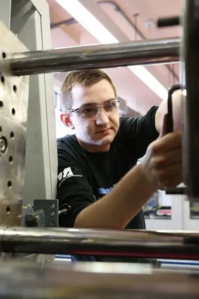 Student working on injection molding machine