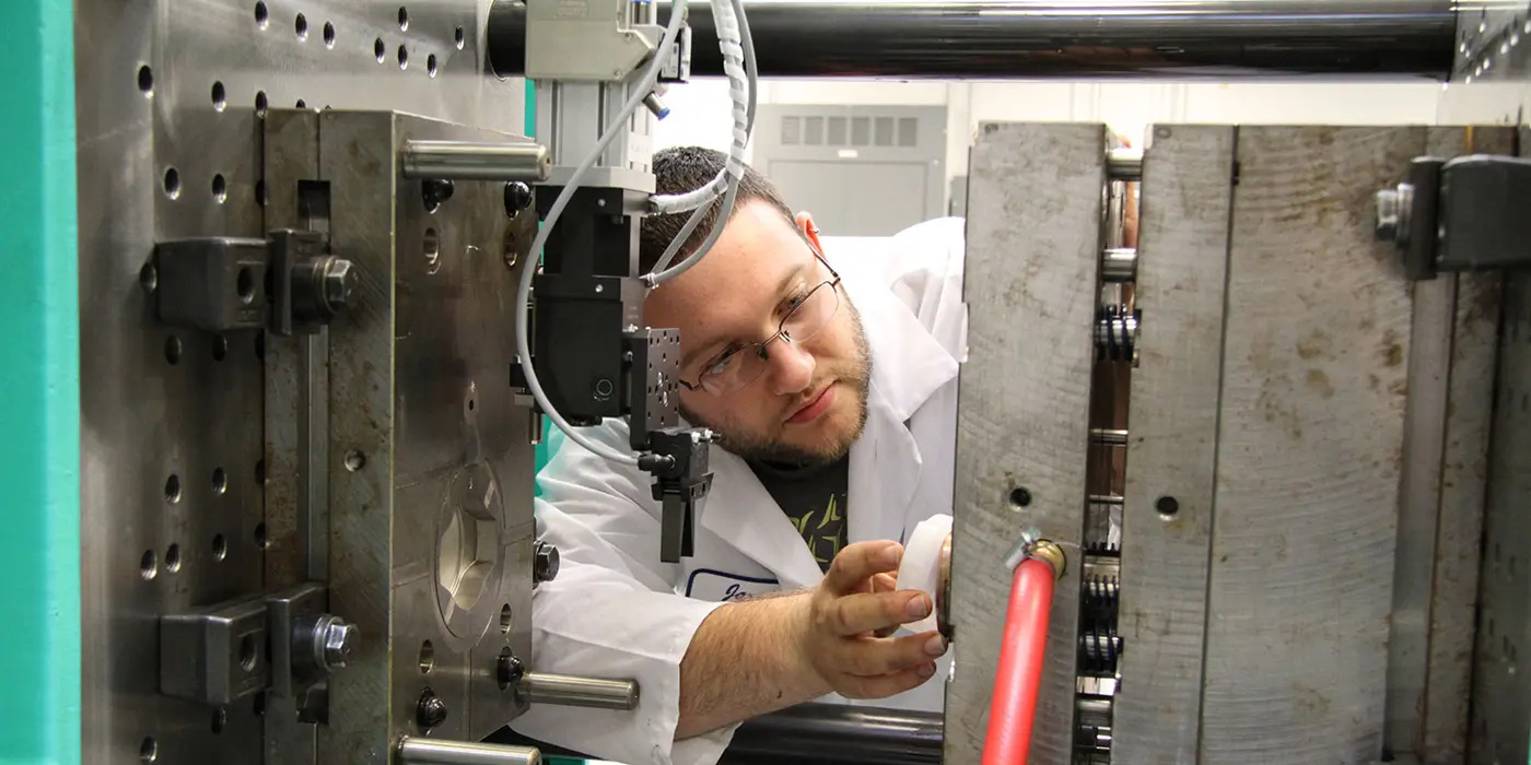 Male student adjusting machine
