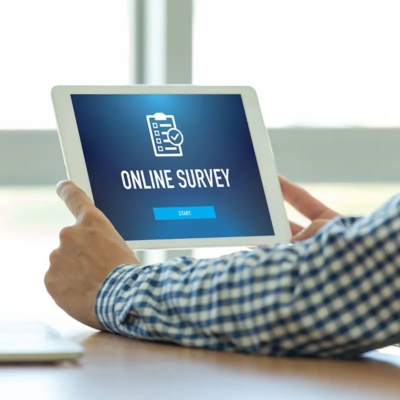 Man's hands holding screen with Online Survey on it