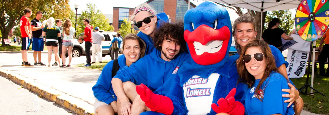 Students gathered around Rowdy The River Hawk, posing, and showing their pride.