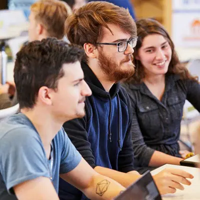 Three students work together at a computer