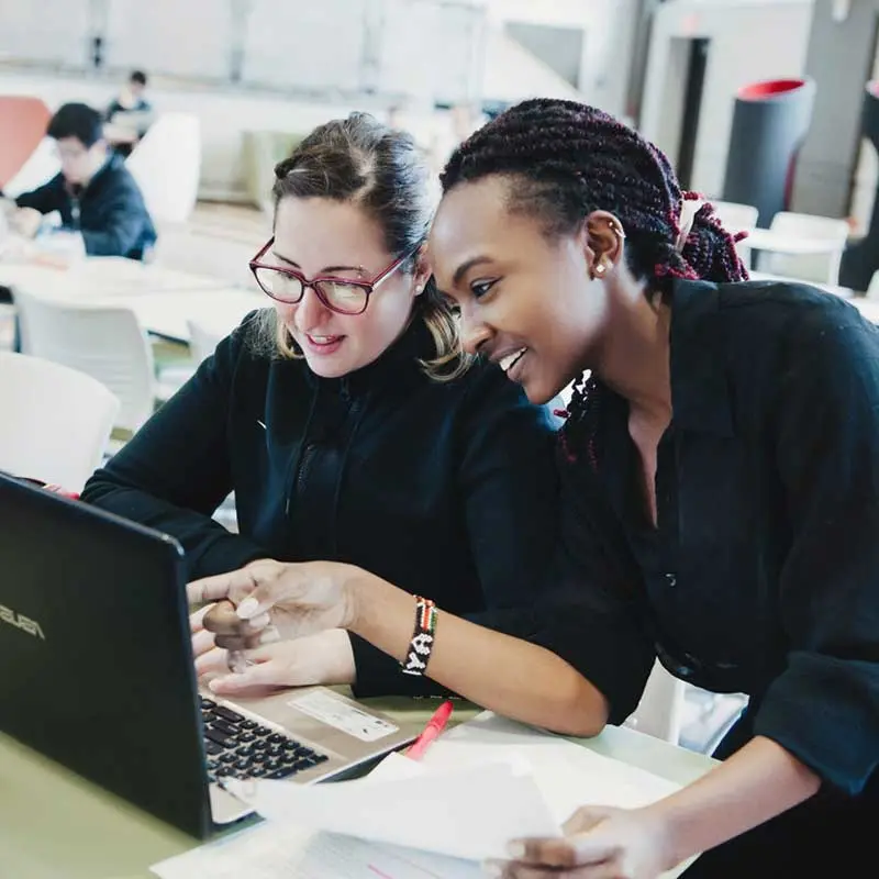 Two students look at a computer together