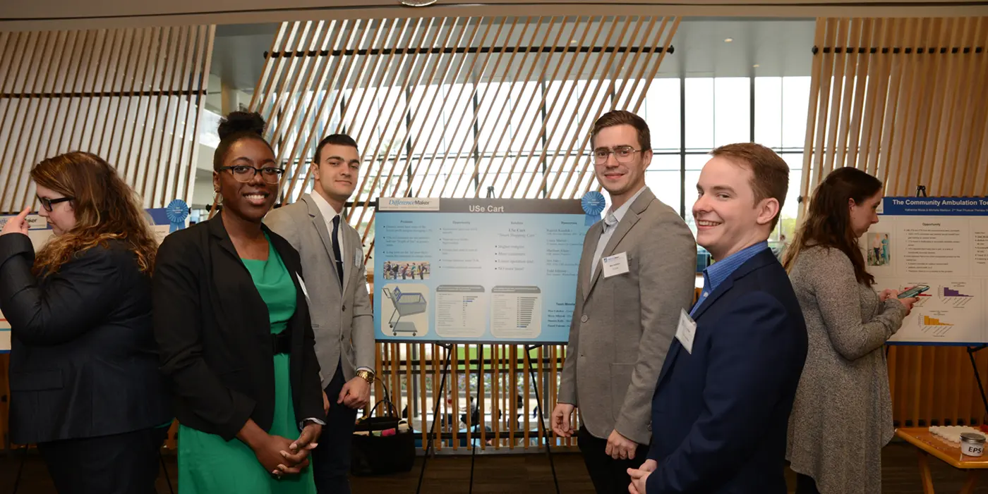  Use Cart team members Max Ushakov, Moya Alhayek and Daniel Falcone stand in front of their poster